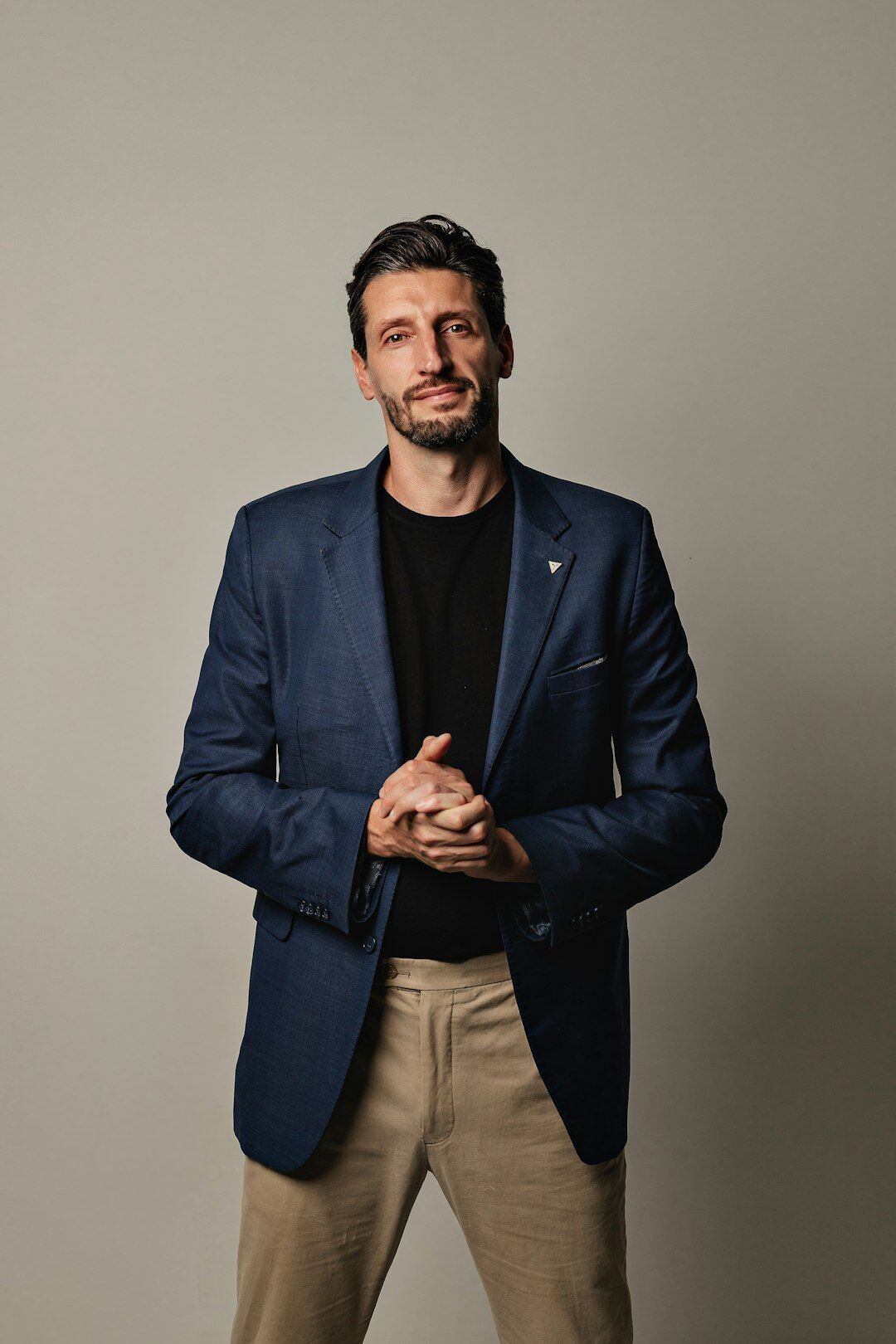 Studio portrait of a Slovenian male media mentor with a beard wearing a blazer